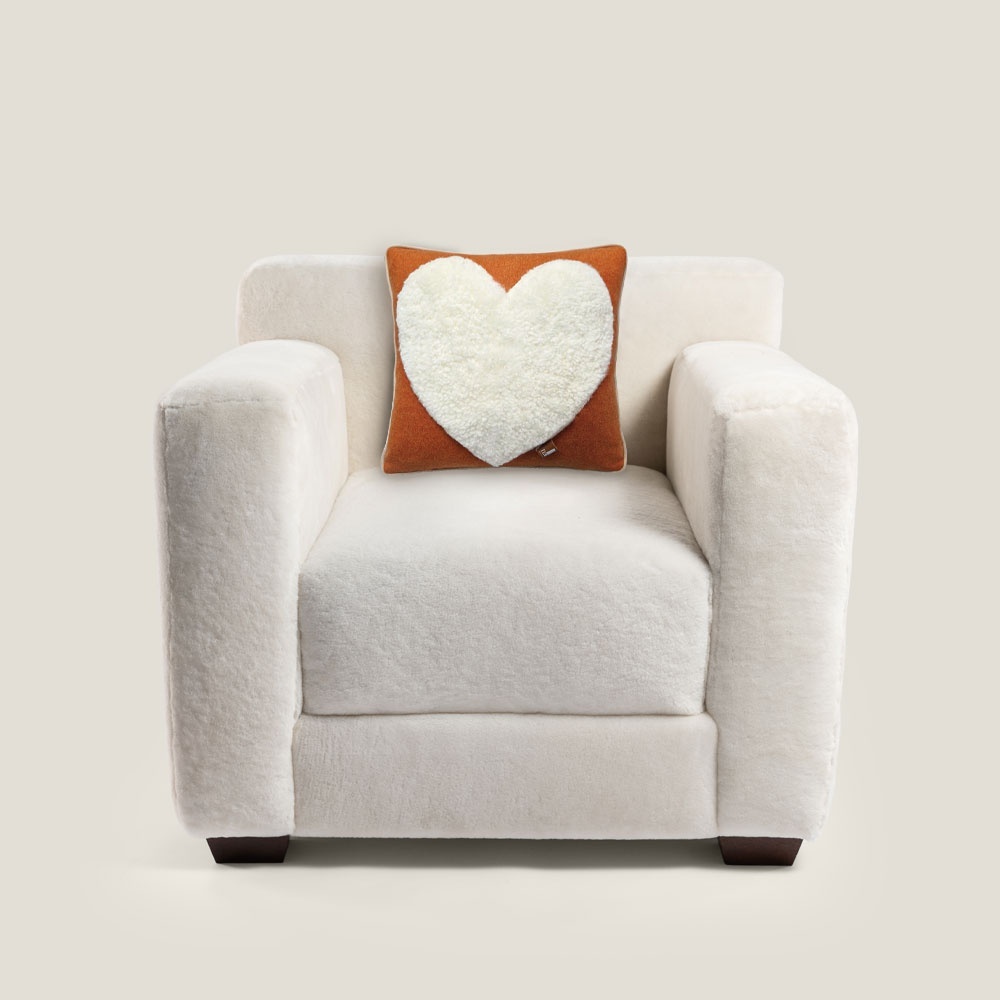 Fauteuil blanc style Frank cube chic et élégant décoré d'un coussin orange avec un motif de coeur