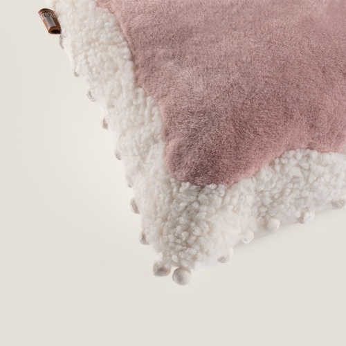 The white silk pompom trimmings make this cushion elegant.