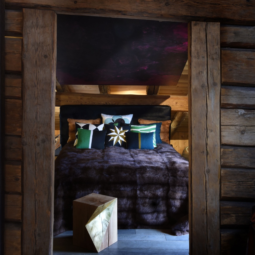 Bed in the bedroom of a wooden chalet covered with a luxurious barguzine sable plaid