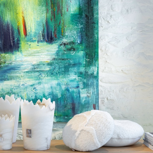 Candles, luxurious white cushion and piece of art for an elegant and refined decoration