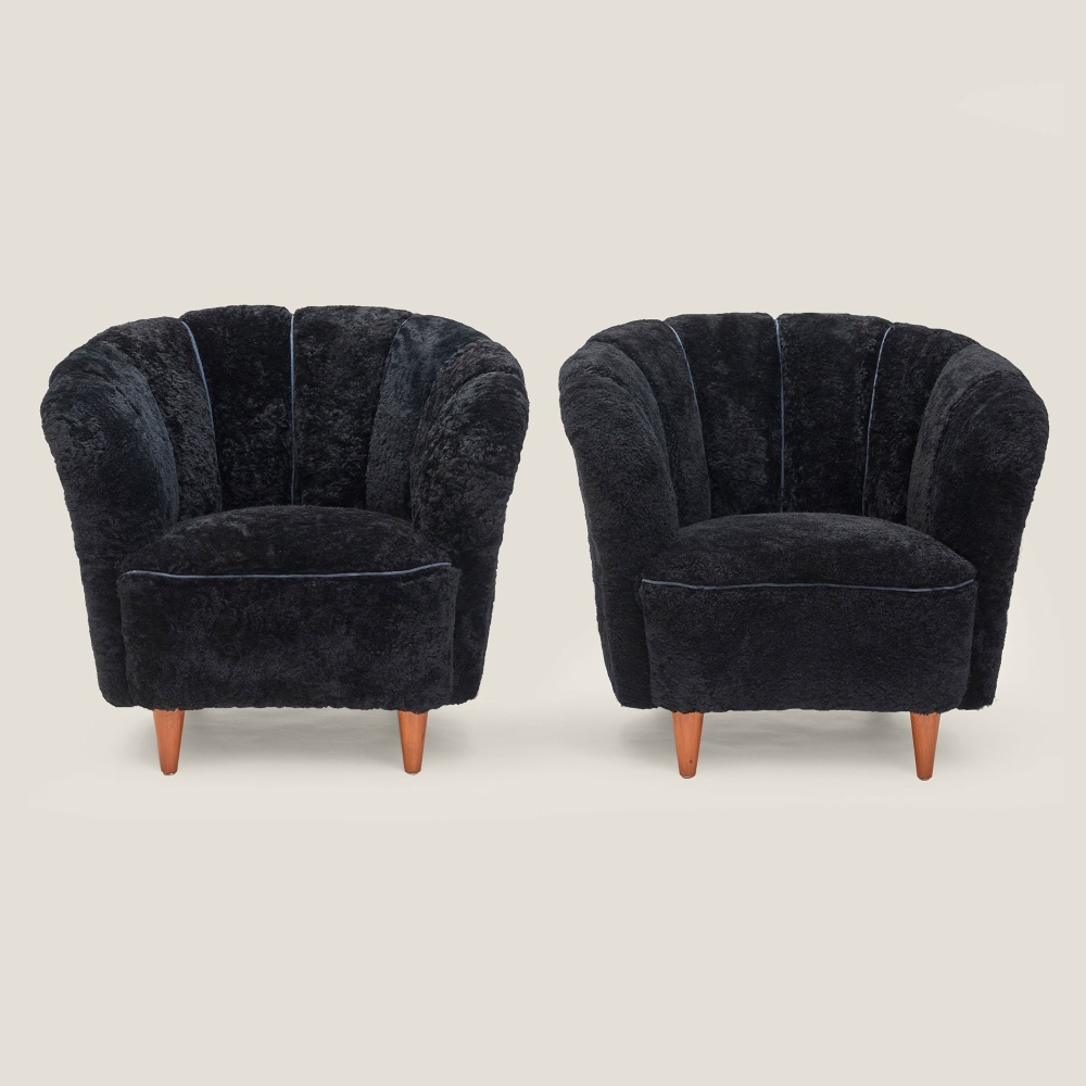 A pair of very chic and super soft black sheepskin living room armchairs