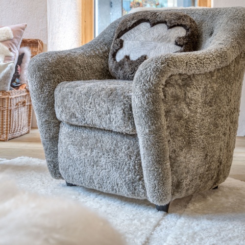 Vintage armchairs with comfortable dimensions accompanied by a small high-end cushion in brown shearling