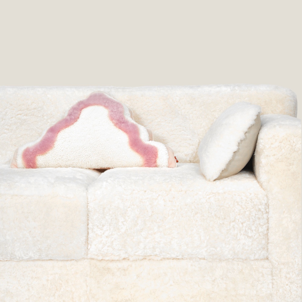 Luxury comfortable sofa in white shearling with pink and white fur cushion