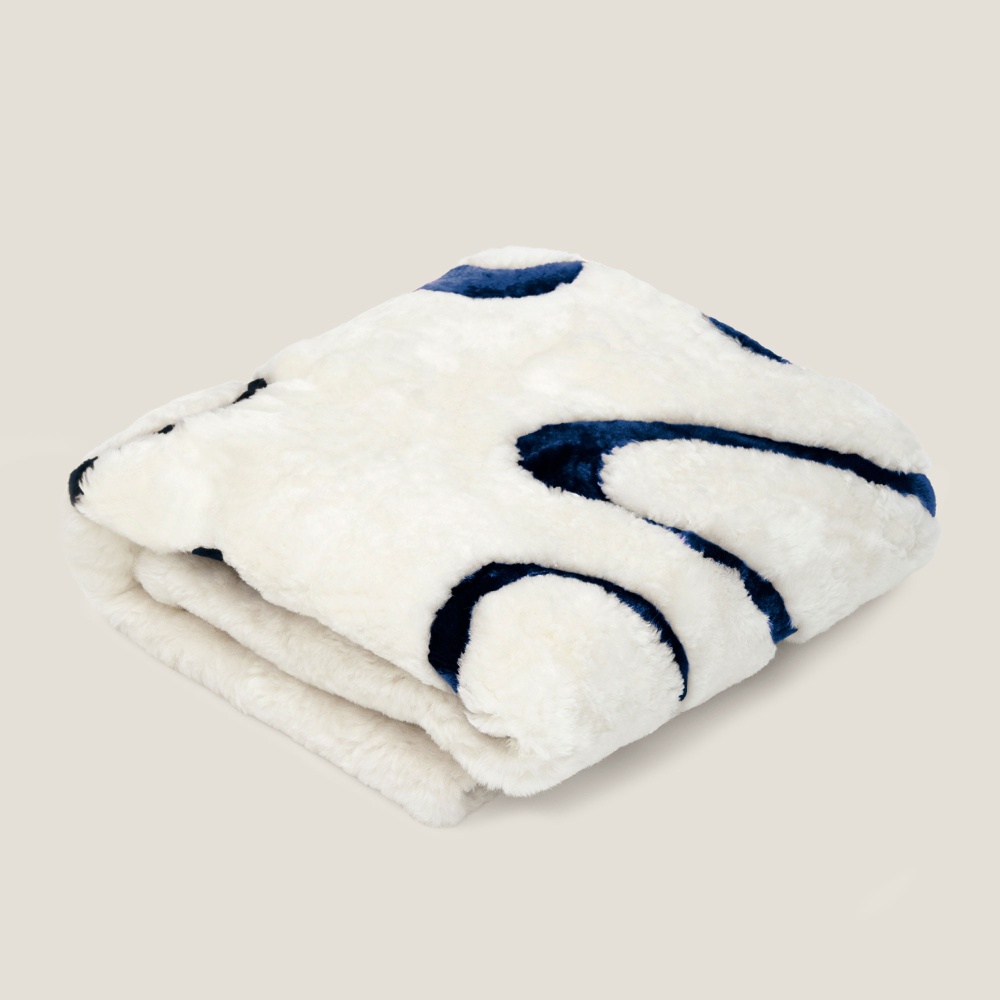 White Square shape throw with a camel pattern reflecting the waves of the North Sea. Wool lining.