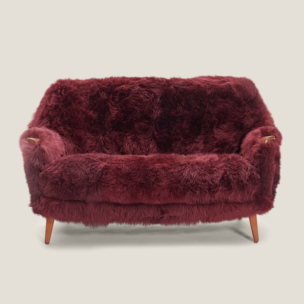 A comfortable vintage sofa upholstered in Bordeaux tinted sheepskin.