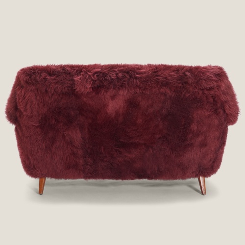 A charming sofa upholstered in long-haired sheepskin with pretty solid oak legs and armrests.