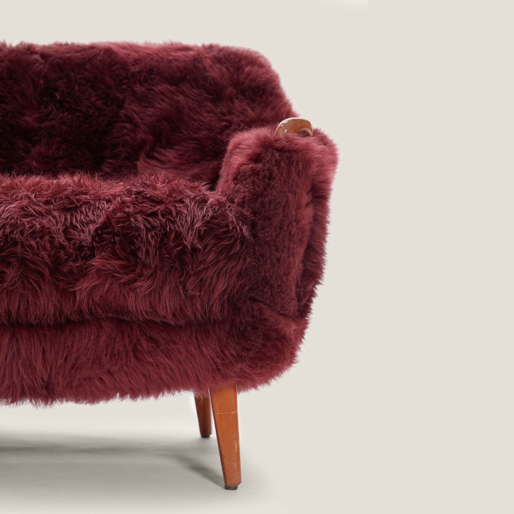 Elegant sofa in Scandinavian merlot oak and sheepskin. A perfect design for your mountain chalet.