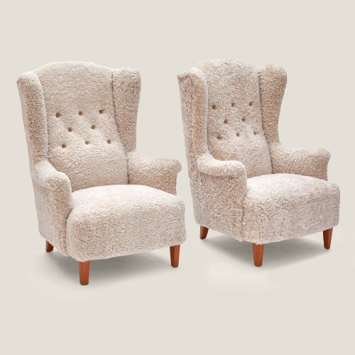 Pair of armchairs signed Carl Malmsten upholstered in oat tinted curly shearling.