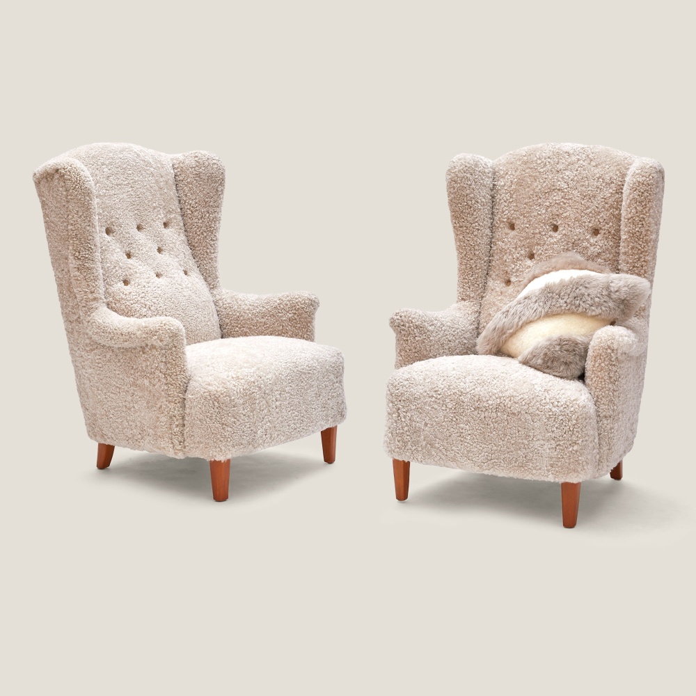 Two oat tinted curly shearling armchairs from 20th-century Scandinavian design by Carl Malmsten.