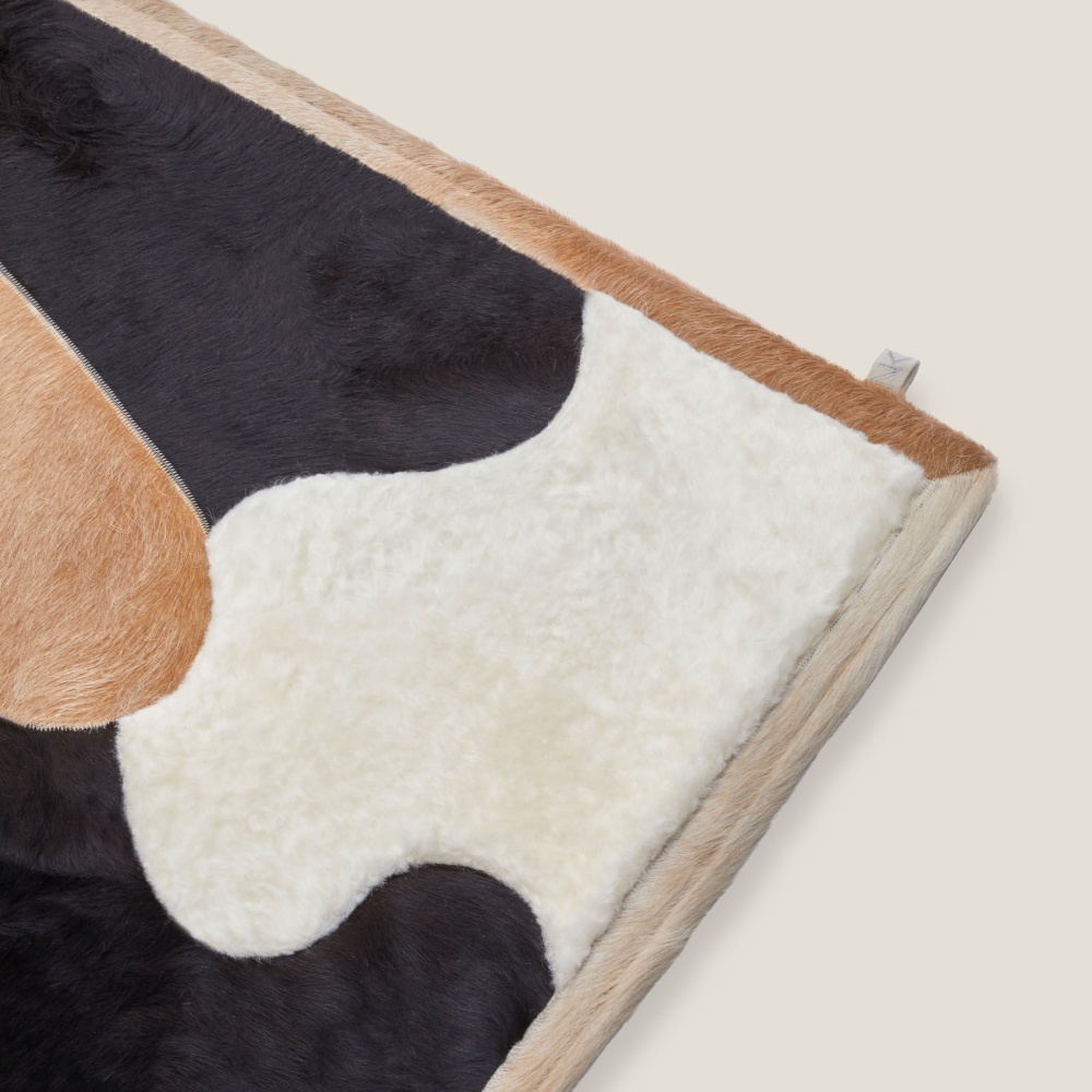 The finishing border in cowhide wrap the Lily rug signed by Norki.