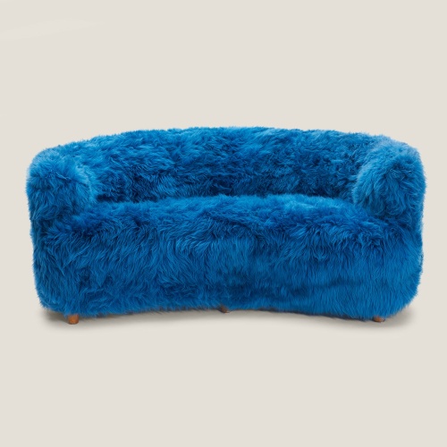 Un canapé scandinave trois places recouvert de mouton poils longs suédois teinté bleu turquoise.