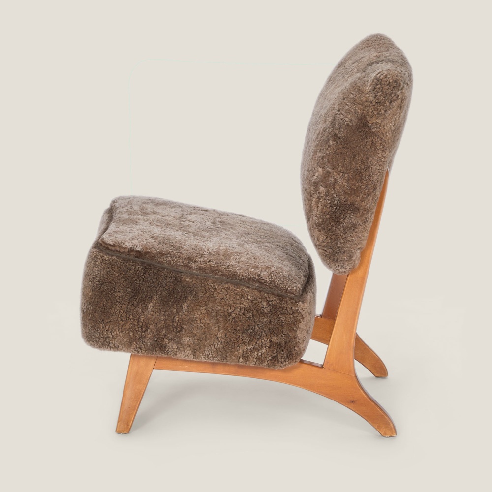 Design armchair, comfortable back and seat with thick brown cushions.