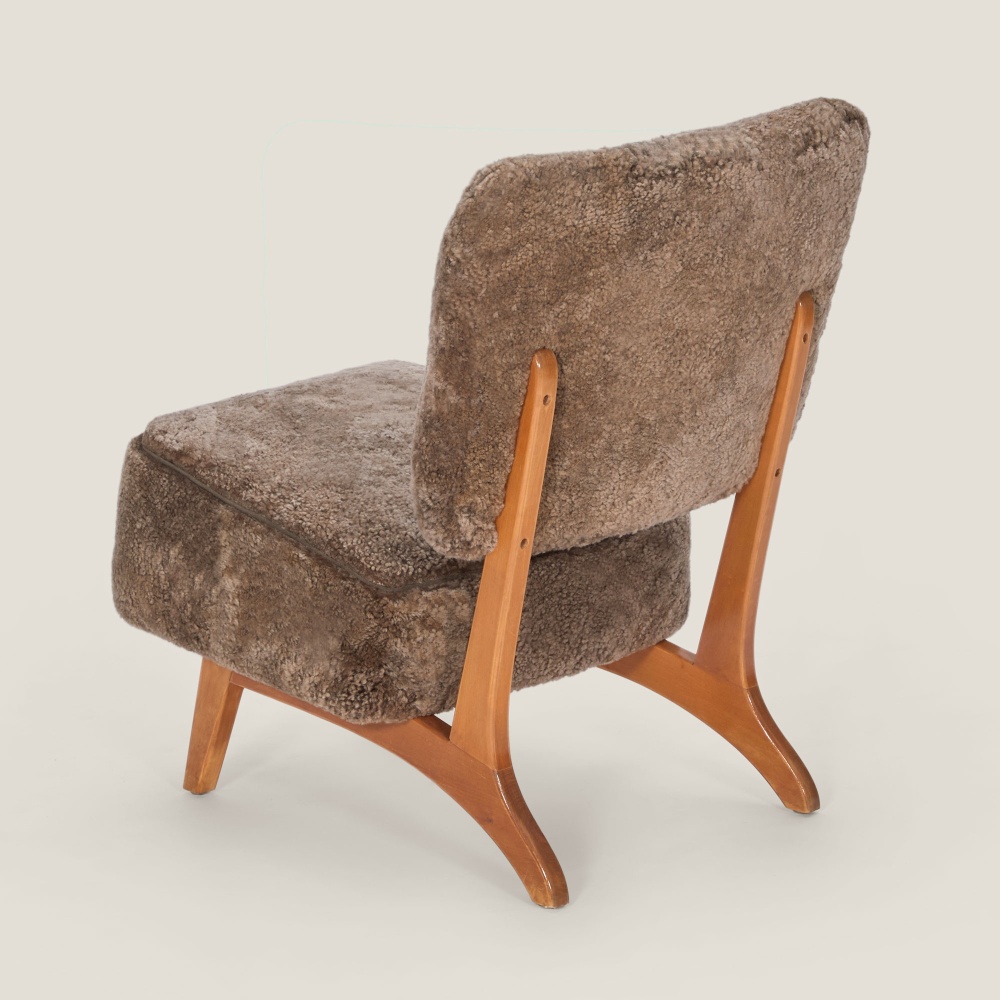 Fauteuil en peau lainée et structure en teck massif pour ce fauteuil de luxe.