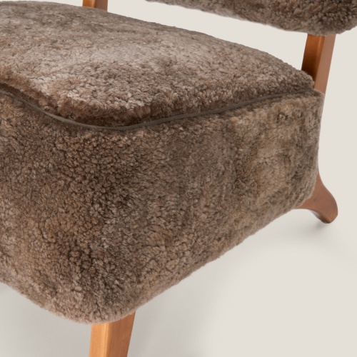 A top-of-the-range armchair with a thick, comfortable seat in curly woollen hide.