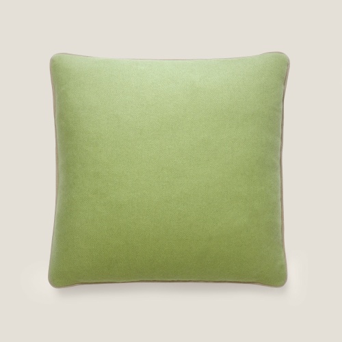 Une face du coussin en tissu vert, une couleur tendance pour la chambre d'un petit garçon.