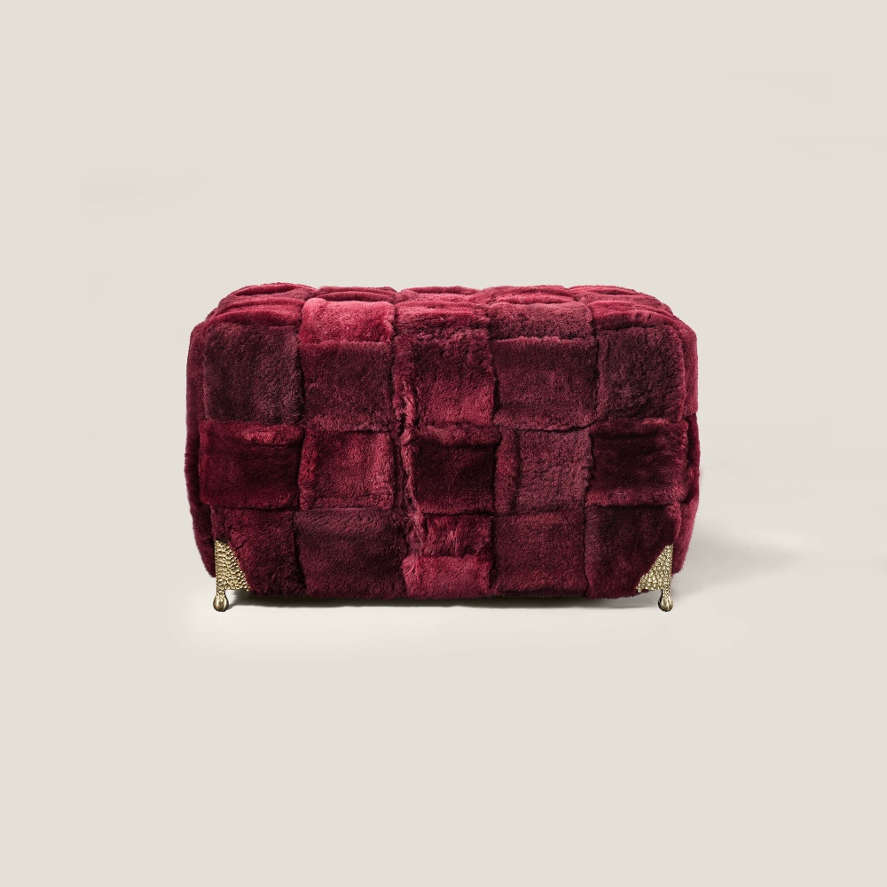 Front view of the large burgundy stool in natural sheepskin, a stool by Norki, haute couture.