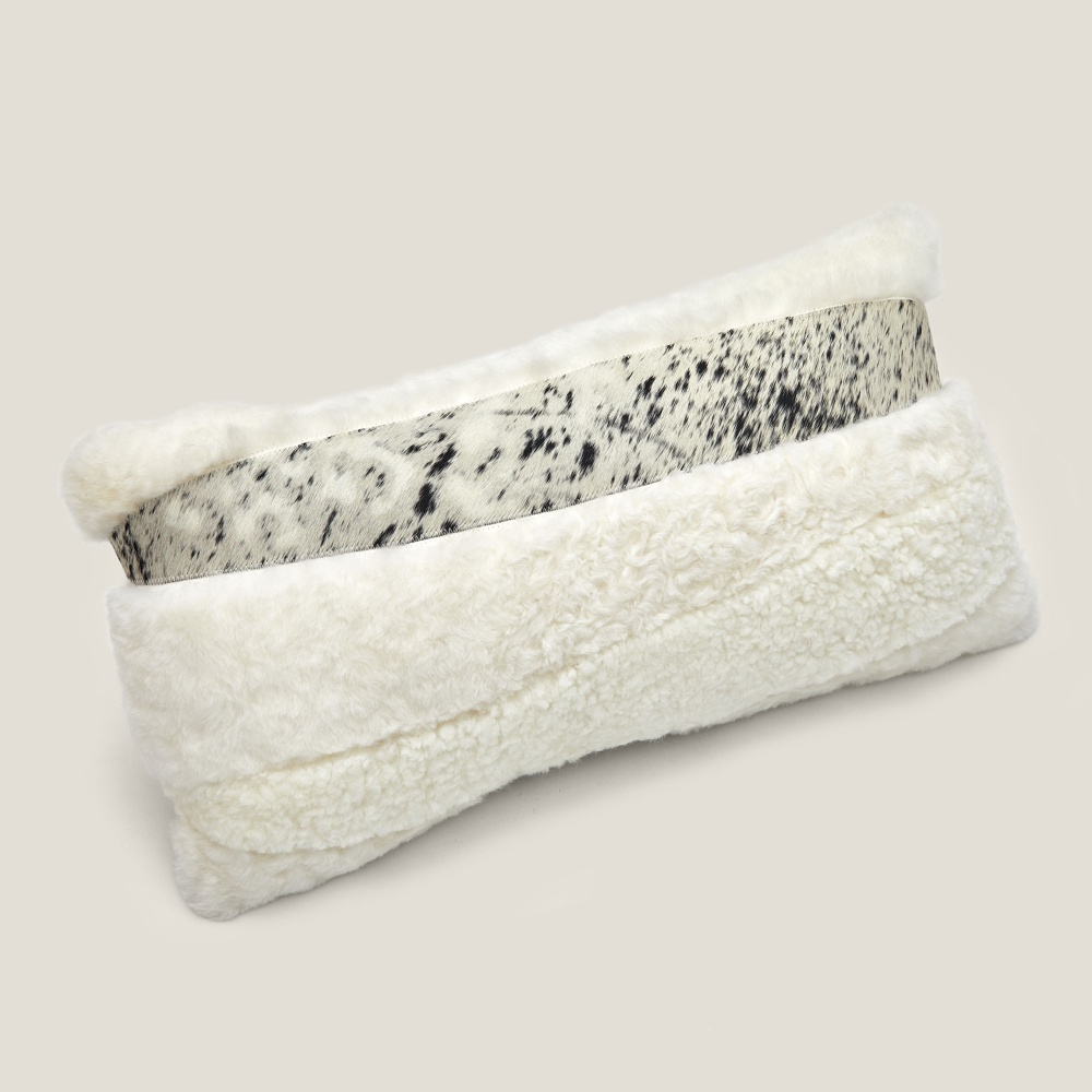 Zima rectangle cushion with white curly shearling, contrasting with cowhide.