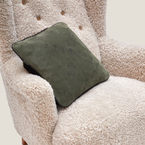 Small khaki cushion embroidered on a vintage armchair in white wool.