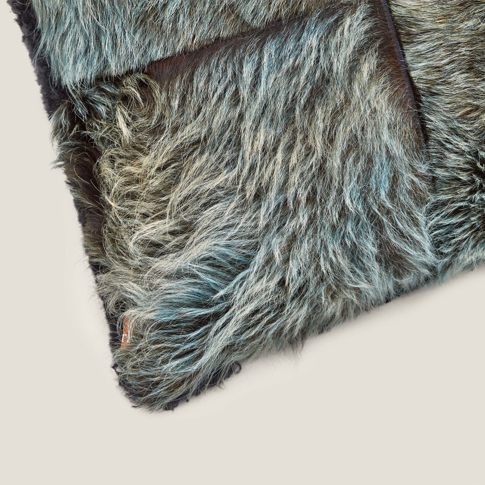 Focus on the blue/green cowhide, assembled on one side of this top-of-the-range cushion by Norki.