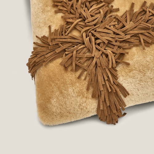 Focus on the detail of the leather straps that form the fringe pattern on this designer cushion.