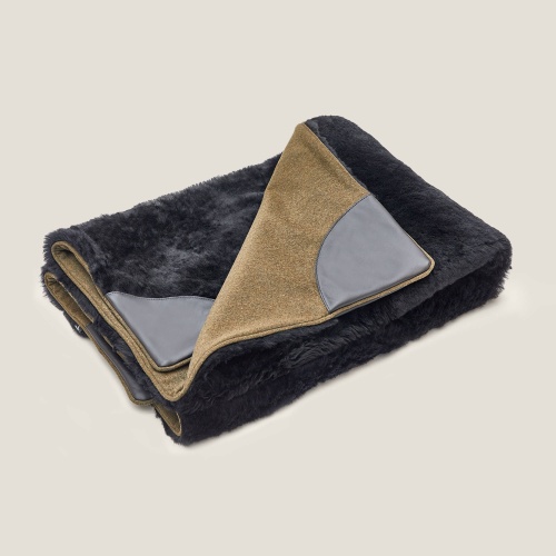 Sarafan throw by Norki, double-sided, one black sheepskin side and one kaki suede leather.