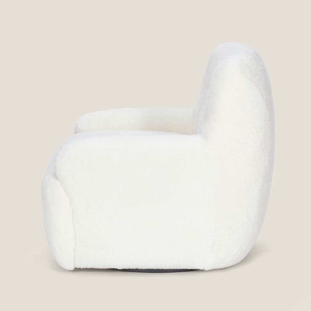 Vue de profil de notre fauteuil Atya blanc en peau lainée naturelle. Fauteuil sur mesure pour une décoration haut de gamme.