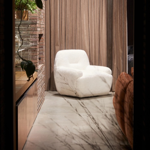 A living-room armchair in white woollen leather with a soft, comfortable seat for modern, minimalist home decor.