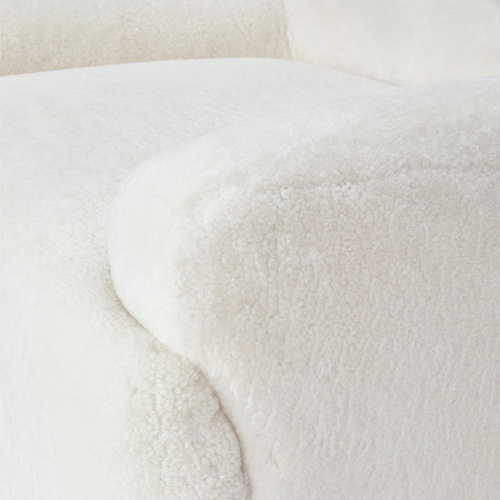 Focus sur les accoudoirs large et confortables de notre fauteuil bouclette blanc Atya by Norki.