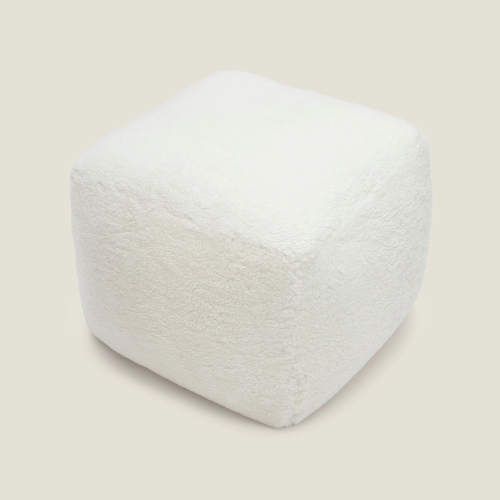 Un pouf de luxe sur mesure en bouclette blanche pour un intérieur design et moderne.