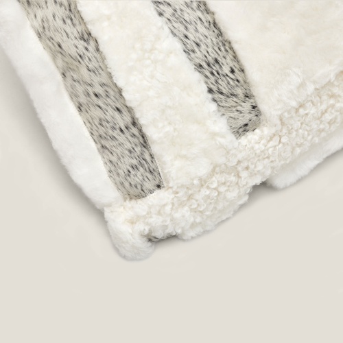 Detail of the hand-crafted finish on the white square Zima cushion with mottled cowhide.