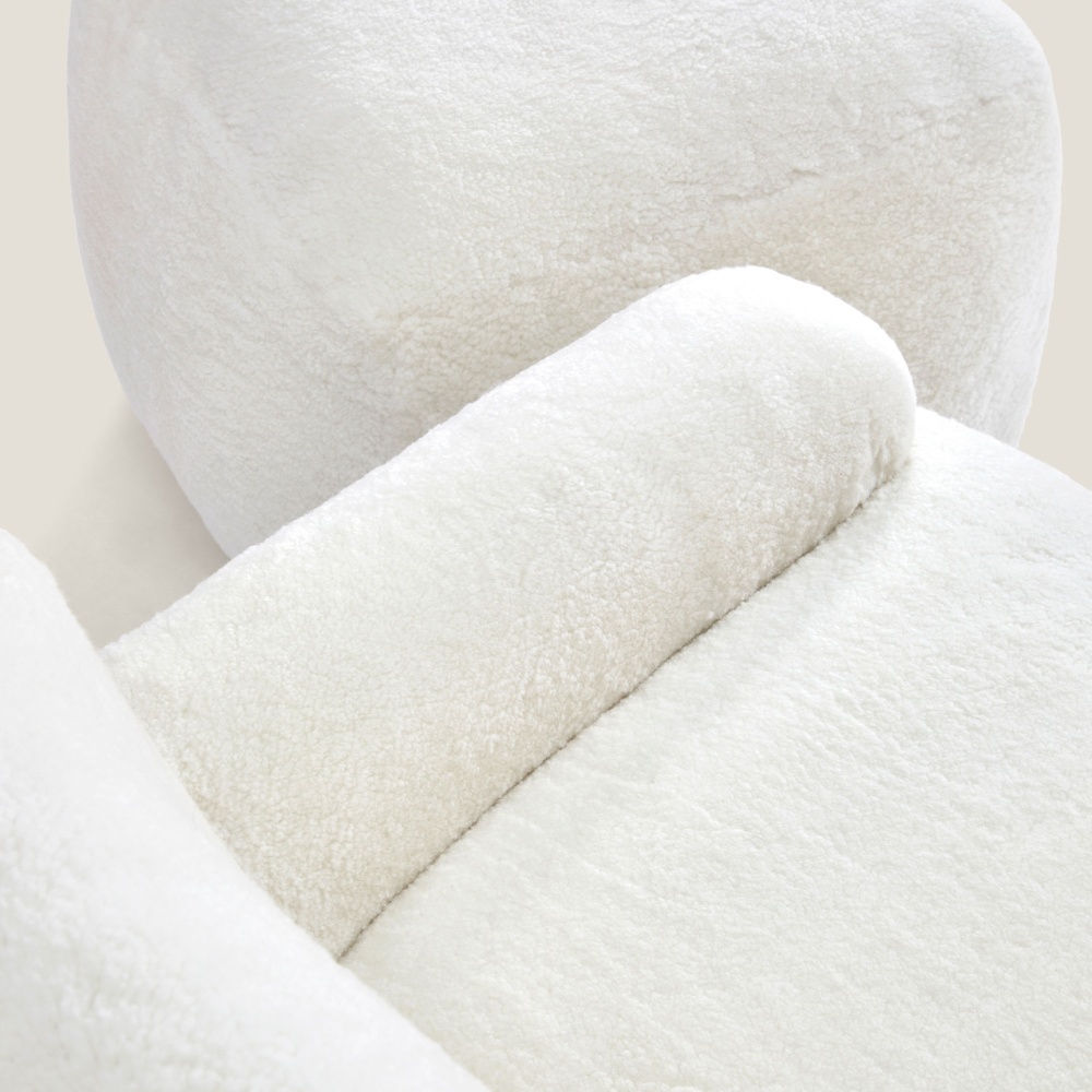 Focus on the luxurious white wool hide of this comfortable armchair and footrest.