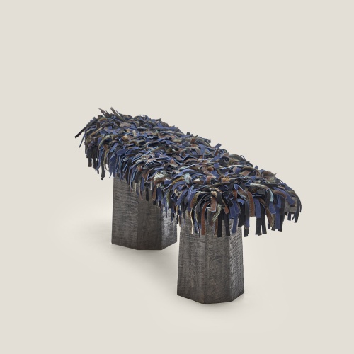 Banc artisanal en chêne massif vieilli avec coussins en peau, parfait pour une décoration brutaliste et authentique.