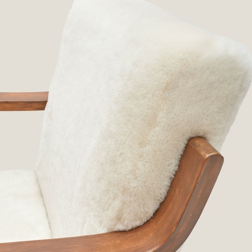 Un fauteuil en peau lainée blanche véritable, bijou du design scandinave pour votre décoration d’intérieur.