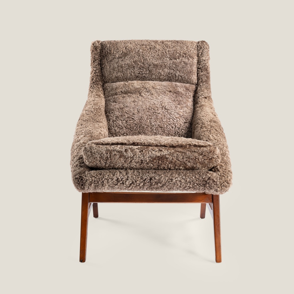 Elegant Siesta armchair with sand-colored sheepskin and ottoman, design by Svante Skogh.