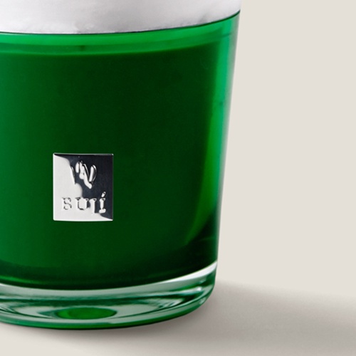 Buji Collection candle in a green glass jar.