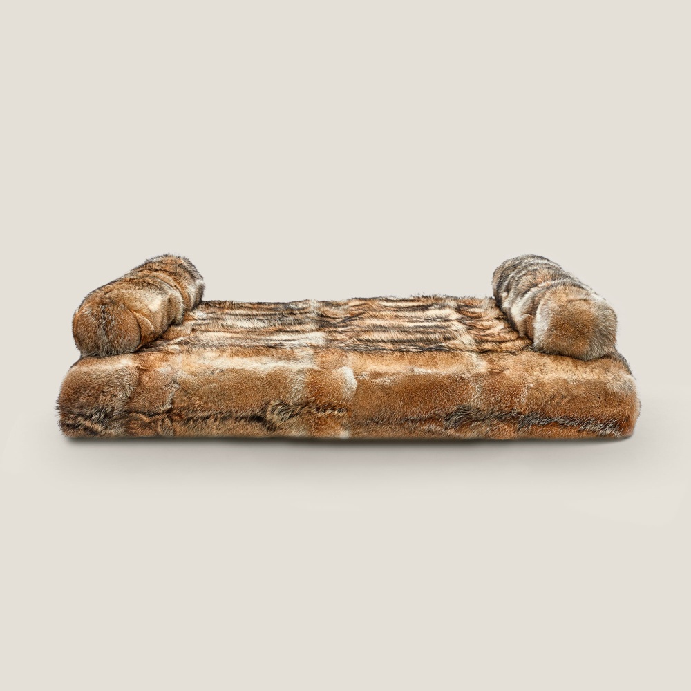 Daybed en fourrure de coyote pour déco chalet tendance.