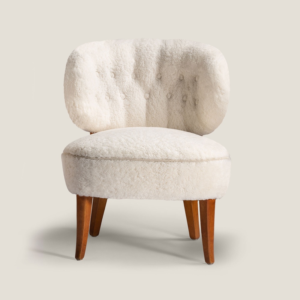 Un petit fauteuil blanc, le fauteuil Gamla Berlin par le designer Carl Malmsten.