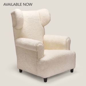 Fauteuil blanc à oreilles de créateur fabriqué en France : un luxueux fauteuil de lecture gainé de peau lainée pour votre salon.