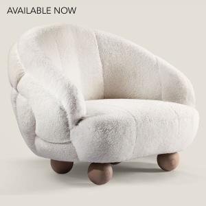 Grand fauteuil blanc de créateur au design signé NORKI. Pieds boule en chêne massif naturel, peau lainée blanche.