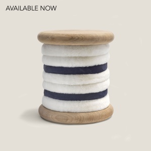 A stool in white and navy-blue sheepskin, oak or birch wood. Seat height 48 cm. Design norki