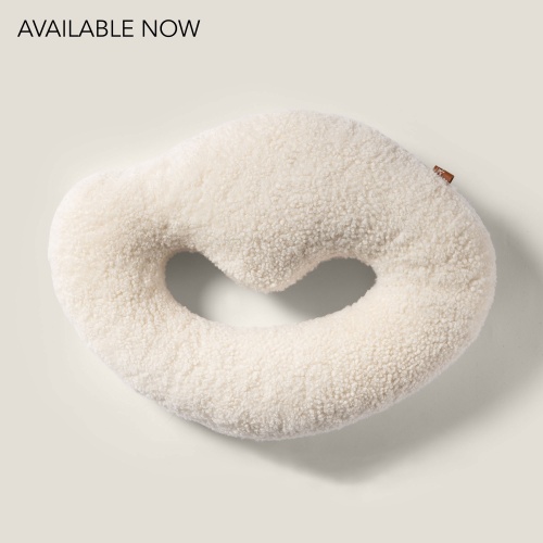 White ring-shaped cushion in curly shearling.