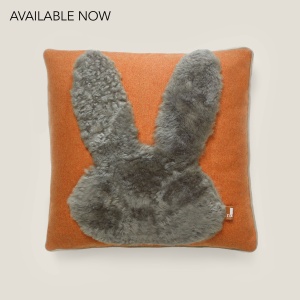 Coussin doux et confortable orange et beige avec une application luxueuse en forme de lapin en peau lainée