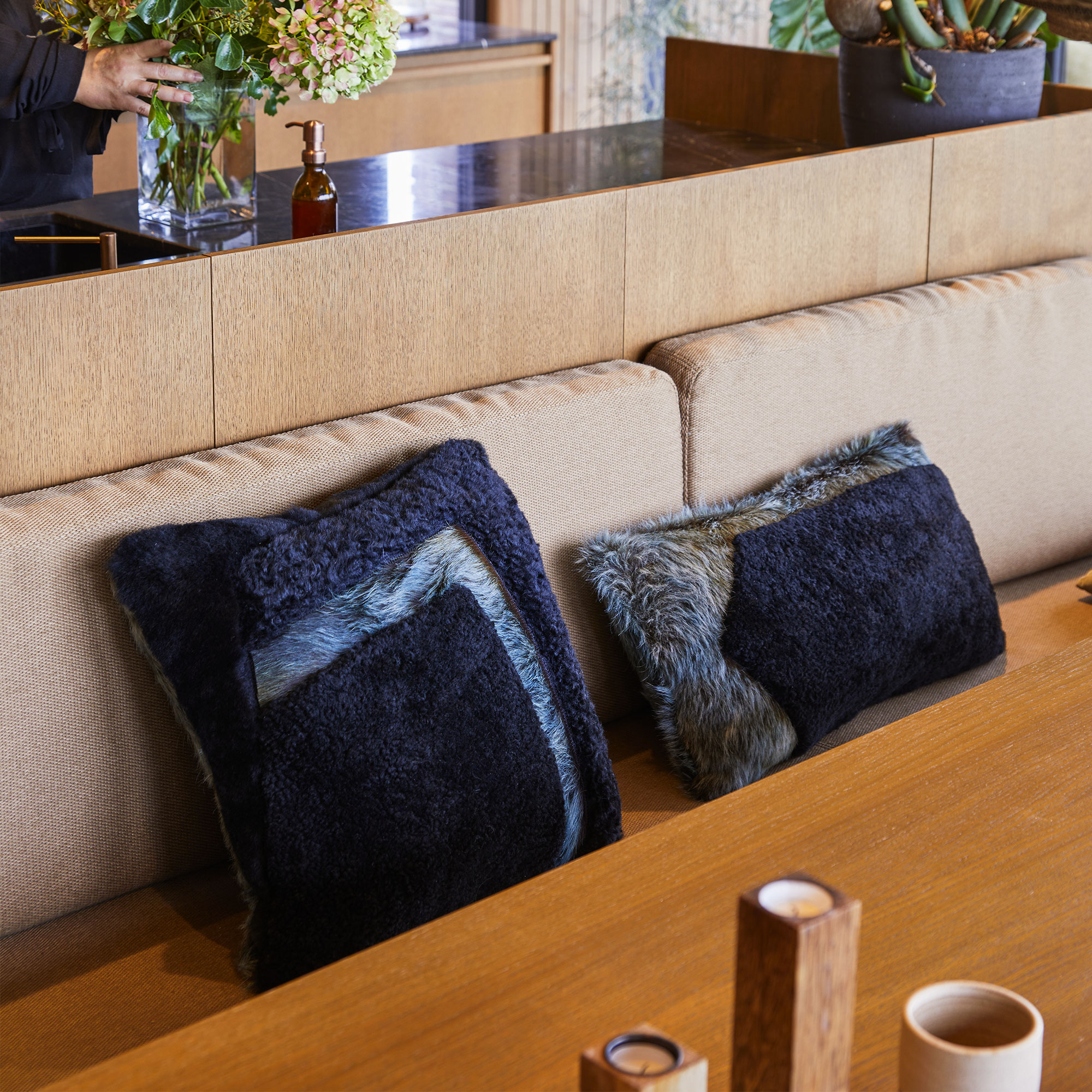 Coussins carré et rectangulaires en peau lainée pour habiller le banc de votre cuisine.