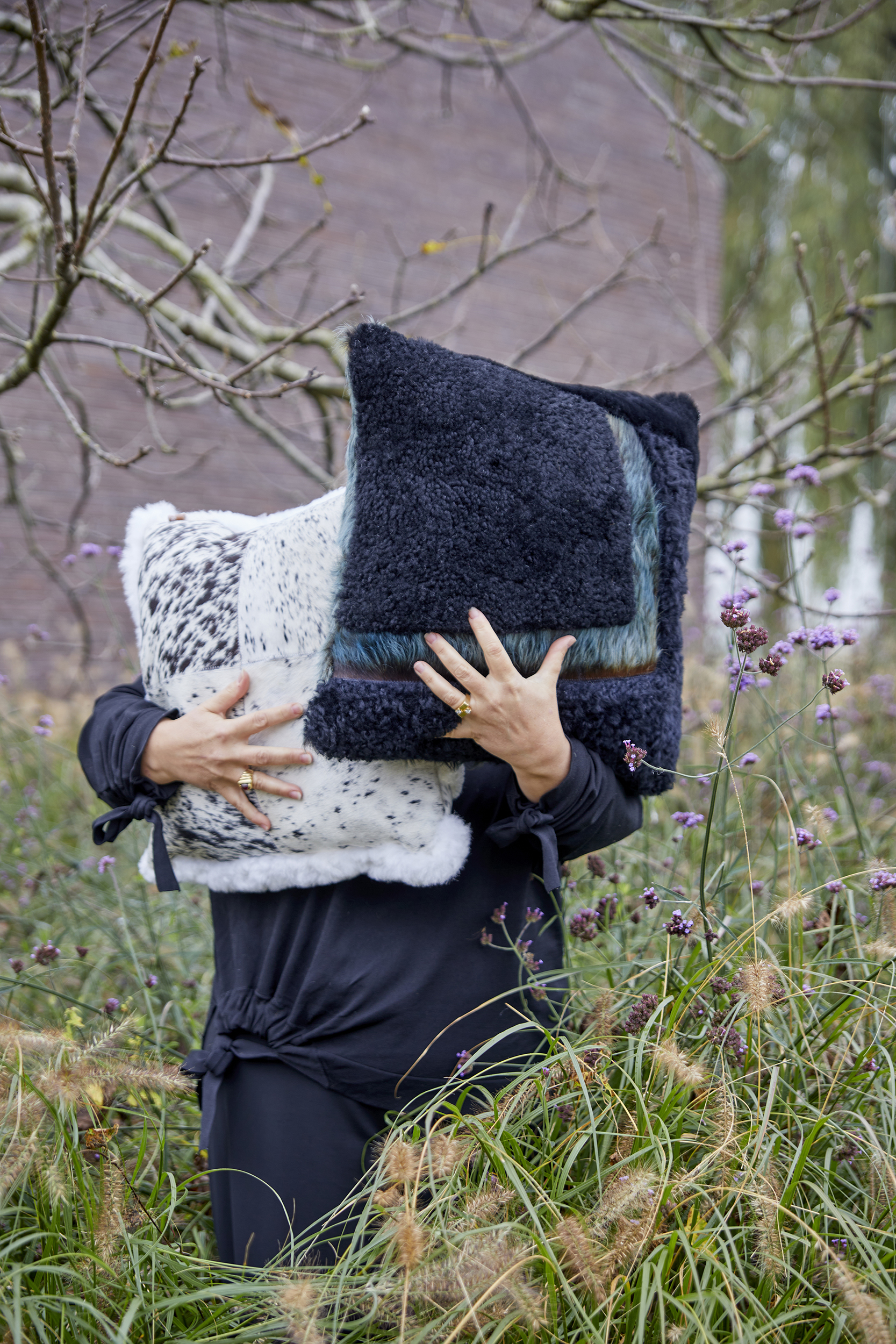 Coussins carrés en peau lainée, doux et confortables, avec des nuances de blanc, gris, bleu et vert.