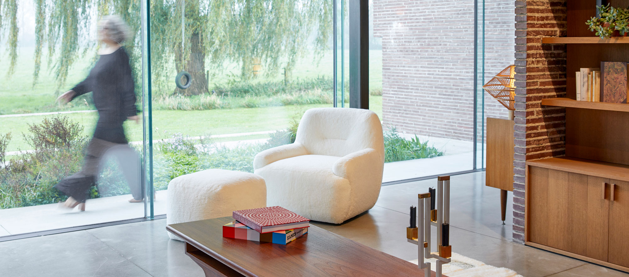 Fauteuil blanc bouclette, confortable en peau lainée et son repose pied cubique assorti.