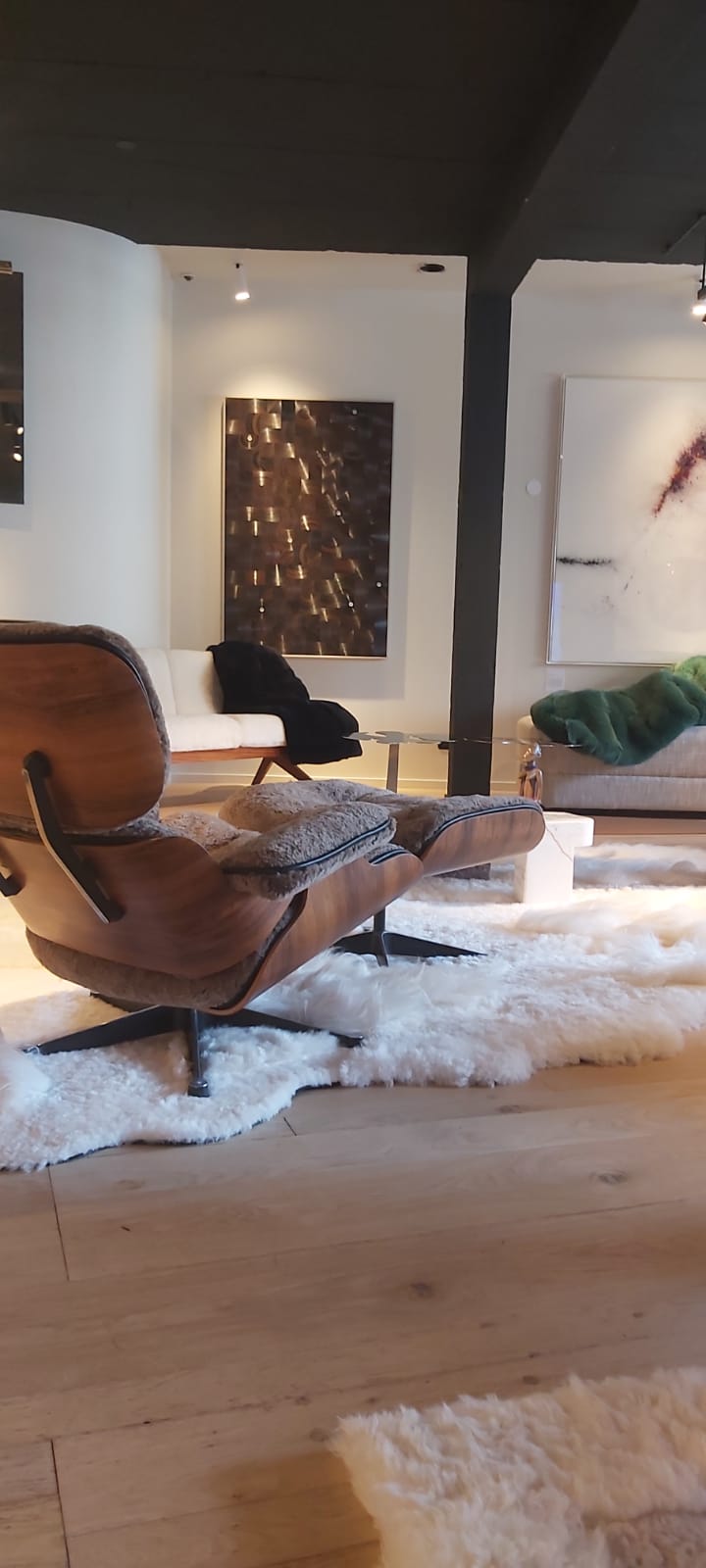 Fauteuil vintage Eames, par le célèbre couple Ray et Charles Eames, restoré en peau lainée beige.