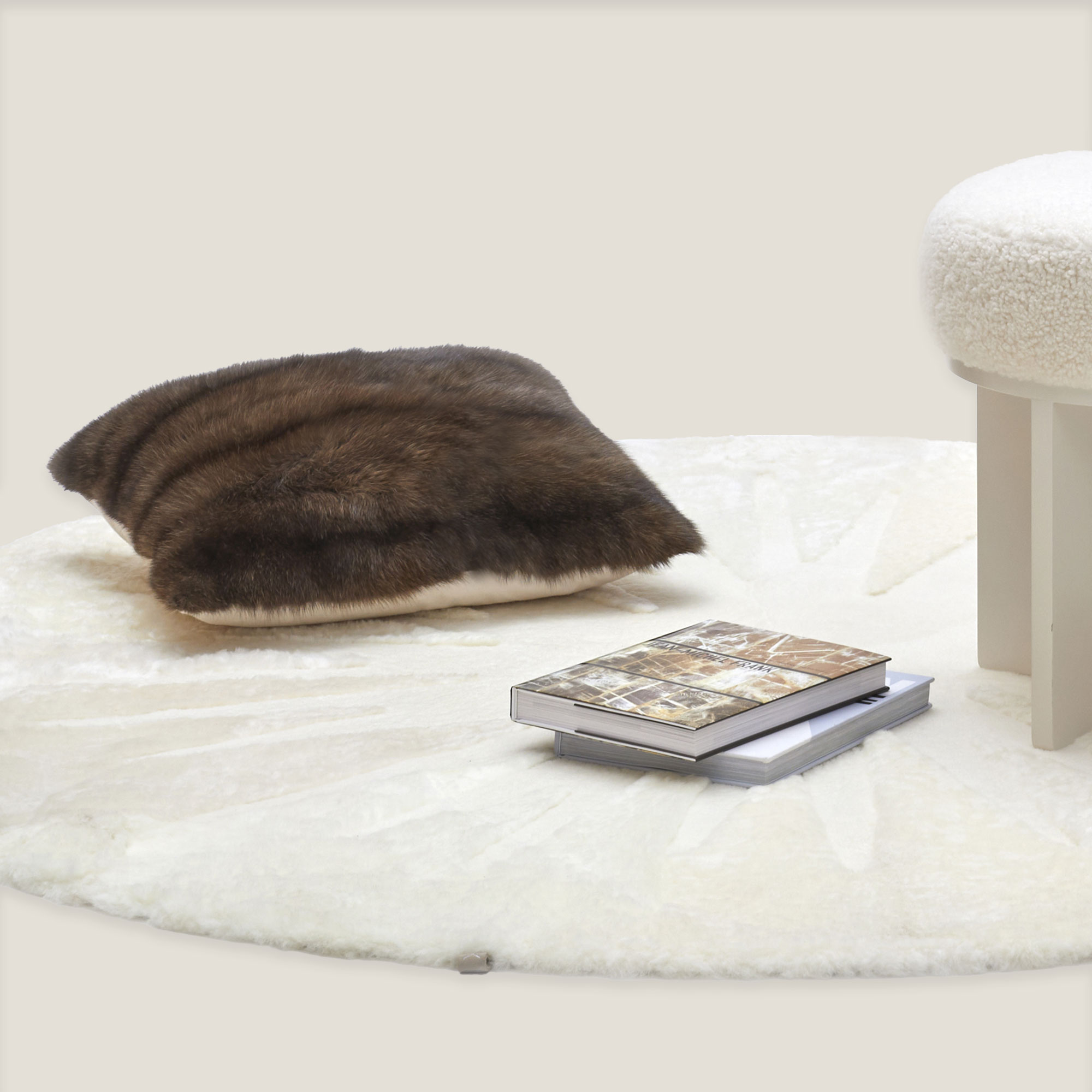 A sable fur cushion on a round white designer rug.