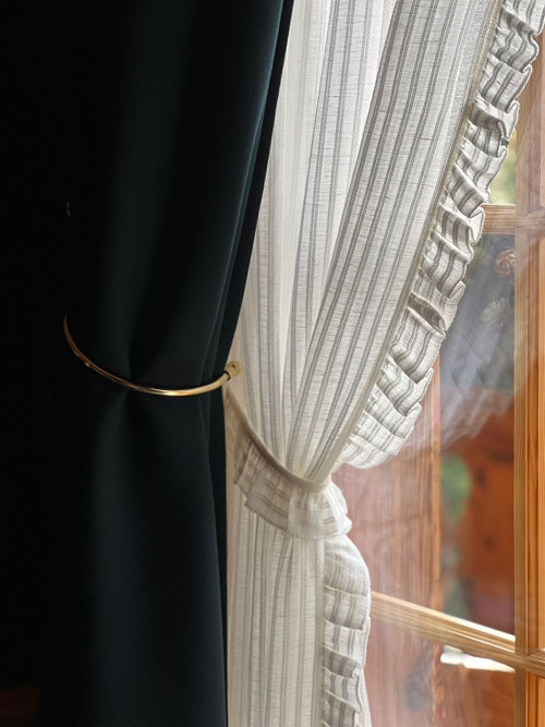 Détail de voilage et rideau sur mesure avec embrasse dorée
