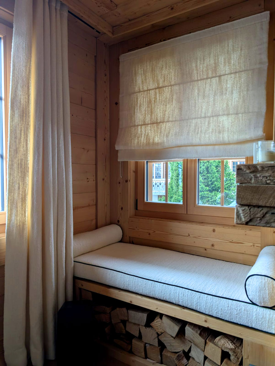 Banquette en tissu sur mesure et store dans un intérieur de chalet