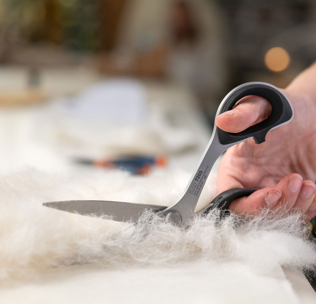 Ciseaux de tailleur découpant de la fourrure dans l'atelier